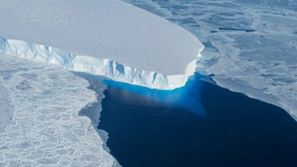 A glacier tongue juts out into dark blue water