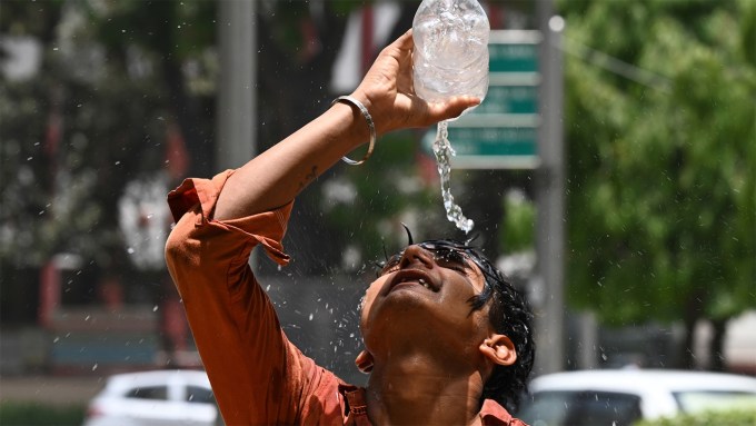 A boy in India pours water over his head.